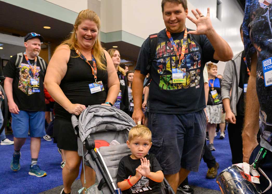 family with baby carriage in the gen con exhibit hall